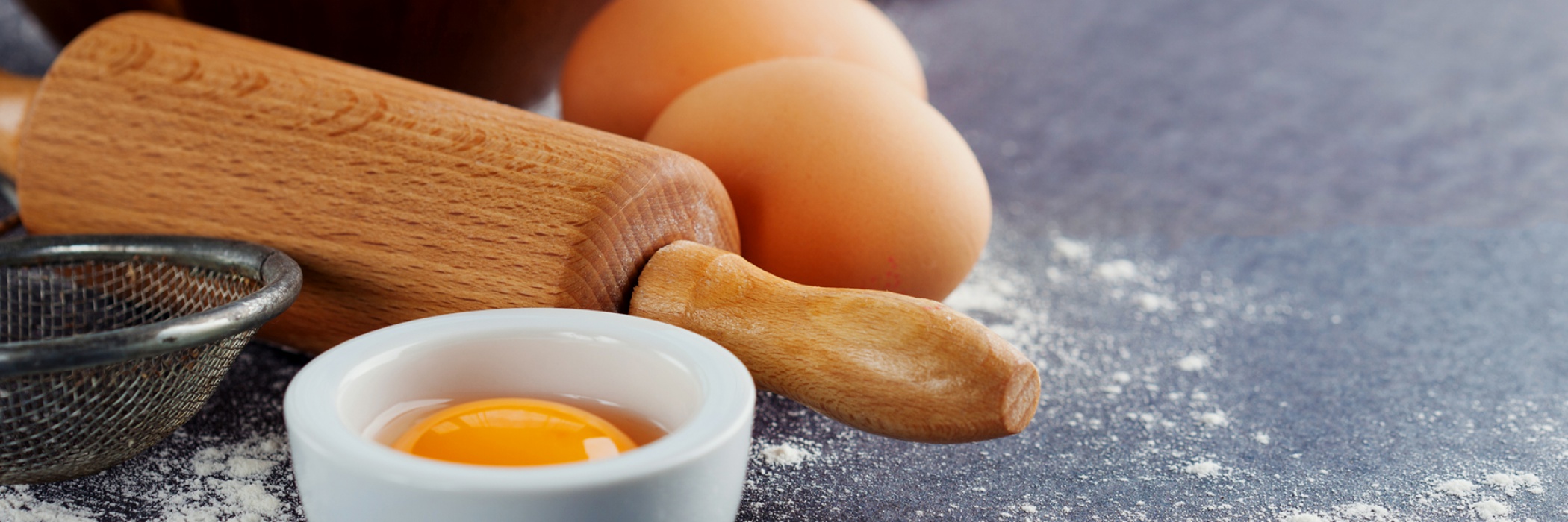 uova fresche sul tavolo con mattarello